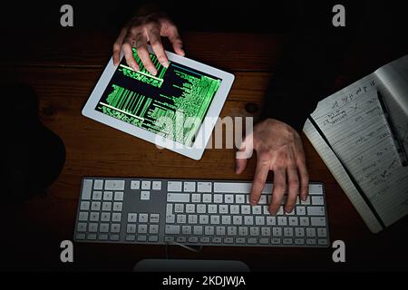 Metadaten sind sein Spielplatz. Hochgedrehte Aufnahme eines nicht identifizierbaren Hackers, der spät in der Nacht einen Computer benutzte. Stockfoto