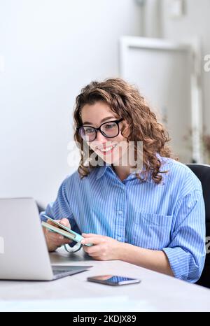 Junge Geschäftsfrau, die online mit einem Laptop arbeitet und sich das Webinar ansieht. Stockfoto