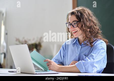 Junge Frau Lehrerin, die Online-Fernvideoklasse unterrichtet, die im Büro arbeitet. Stockfoto