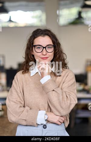 Junge glückliche professionelle Geschäftsfrau trägt Brille, vertikales Porträt. Stockfoto