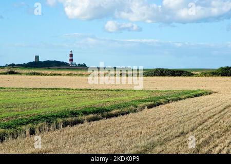 Happisburgh Leuchtturm in der Ferne über Felder im Norden Norfolk England Großbritannien Stockfoto