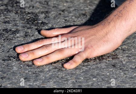 München, Deutschland. 07.. November 2022. Ein Klimaaktivist hat die Hand auf die Straße am Karlsplatz in der Innenstadt gesteckt. Quelle: Sven Hoppe/dpa/Alamy Live News Stockfoto