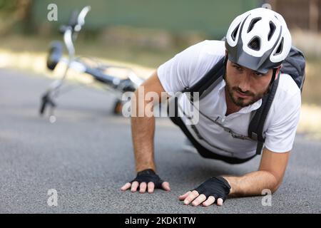 Mann Radfahrer fiel von Rennrad während des Radfahrens Stockfoto