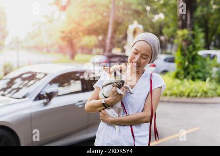 Schöne Frau hält Chihuahua Hund im Garten draußen. Stockfoto