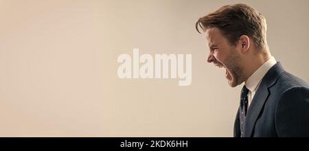 Schreiend und schreiend. Mann Gesicht Porträt, Banner mit Kopieplatz. Geschäftsmann im Anzug, isolierter Studiohintergrund, Bannerplakat. Wütender Mann brüllt grau Stockfoto