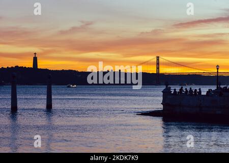 Menschen genießen den Sonnenuntergang über dem Fluss Tejo in Lissabon Stockfoto