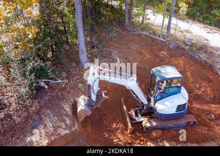Raupenbagger-Eimer graben Boden während Erdarbeiten auf der Baustelle Stockfoto