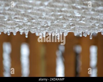 Eiszapfen hängen gefroren vom Seilboden mit selektivem Fokus. Stockfoto