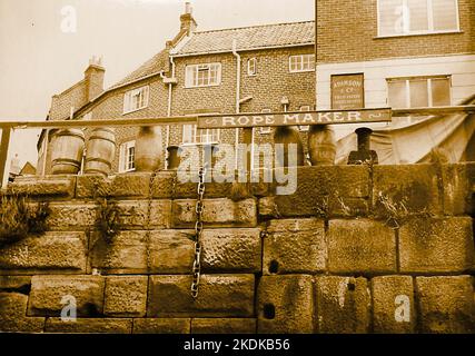 Seilmacher-Schild, Kette und alte Fässer. Tate Hill Pier, Whitby, Yorkshire. ((aus einem Film, der in der Stadt gedreht wird) Stockfoto