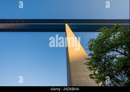 Blick auf eine Säule der 136m hohen Moseltalbrücke bei Sonnenaufgang mit Baum davor Stockfoto