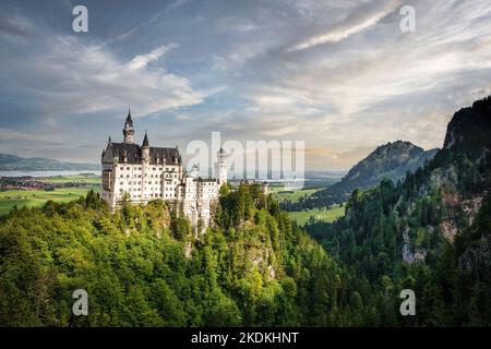Schloss Neuschwanstein liegt hoch über der bayerischen Landschaft in Süddeutschland am Fuße der Alpen. Stockfoto