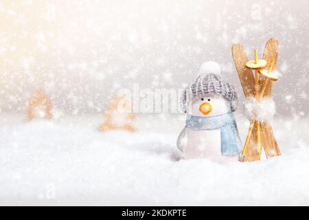 Komposition zu Winterweihnachtszeit. Spielzeug Pinguin mit Skiern im Schnee. Stockfoto