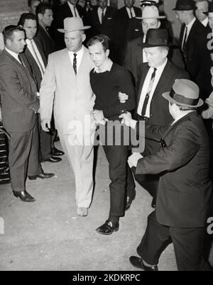 Lee Harvey Oswald wird von Jack Ruby angeschossen, während Oswald von der Polizei bewegt wird, 1963. Stockfoto