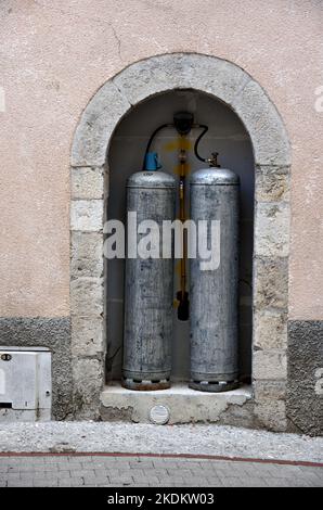 Gaz-Flaschen, Gasflaschen, Flaschengas, Gasflaschen oder Flüssiggas-LNG werden in der Nische des Gebäudes gelagert Stockfoto