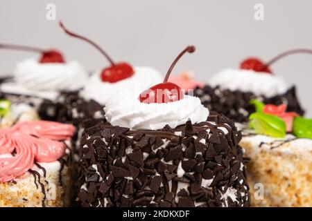 Kuchen mit Schokolade, Kirschen und Creme auf weißem Hintergrund. Stockfoto