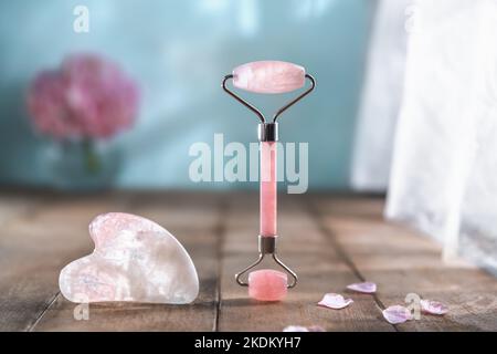 Rosenquarz Gua Sha Massageschaber und Gesichtsmassagerolle. Anti-Aging-Behandlungen. Gesichtspflege. Gouache-Set Stockfoto