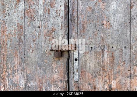 Alte grunge Holztür mit antikem rostigen Vorhängeschloss Stockfoto