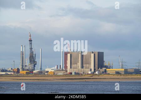 Kran in der Able-Recyclinganlage neben dem Kernkraftwerk Hartlepool, der große Turbinenschaufeln eines Windparks auf ein Installationsschiff lädt Stockfoto