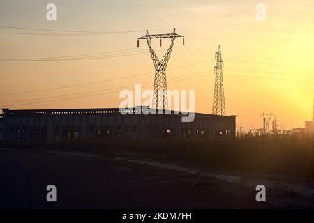 Leere Straße mit verlassenen Lagerhäusern und Pylonen bei Sonnenuntergang Stockfoto