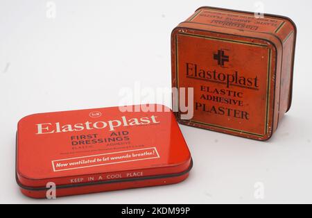 Elstoplast wurde als Produkt von der deutschen Firma Beiersdorf entwickelt (die es noch besitzt). Ihre Website schlägt vor, dass sie das Produkt im Jahr 1896 entwickelt haben. Smith & Nephew (gegründet 1856) erwarb 1928 die Lizenz für die Marke. Unnötig zu sagen, dass sich die Verpackung im Laufe der Jahre stark verändert hat und diese beiden Beispiele stammen aus dem Jahr 1930s und dem Jahr 1960s. Die robusten Dosen haben in einigen Zahlen überlebt und werden oft viele Jahre lang von Familien in ihrem Medizinschrank wiederverwendet und für andere Zwecke recycelt. Das Metall wurde vor langer Zeit ausgelaufen und die Putze werden jetzt in Kunststoffkartons eingelagert. Stockfoto