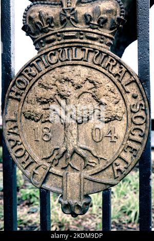 WISLEY RHS Eingangsschild Metall verwitterte Abzeichen Royal Horticultural Society (RHS) Metallplakette datiert 1804 Emblem an den Eingangstoren Wisley Surrey UK Stockfoto