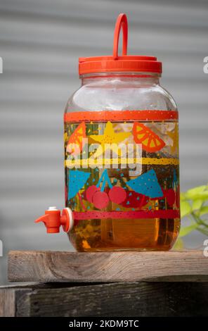 Erfrischender Eistee, der an einem Sommertag in Missouri in der Natur von der Sonne gebrüht wird, wird bald genossen werden. Das bunte Glas macht es zu einer festlichen Szene mit einem Defo Stockfoto