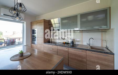 Modernes Interieur der Holzküche in Luxus-Wohnung. Privates Haus. Stockfoto