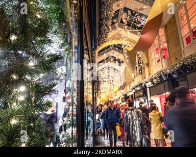 DAS INNERE DER BURLINGTON ARCADE WEIHNACHTSEINKÄUFE EINKAUFSBUMMEL MENSCHENMENGEN IM INNEREN charmante, einladende viktorianische Burlington Arcade in Piccadilly mit traditionellen Weihnachtsdekorationen und funkelnden Lichtern und Einkaufsbummel durch Piccadilly London Großbritannien Stockfoto