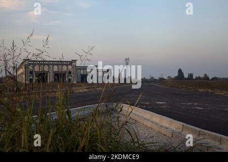 Gabelung in einer leeren Straße in einem Industriekomplex bei Sonnenuntergang Stockfoto