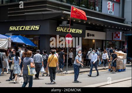 Hongkong, China. 05. Oktober 2022. Fußgänger kommen an einer chinesischen Flagge neben dem amerikanischen Lifestyle- und Performance-Schuhgeschäft Skechers in Hongkong vorbei. (Foto von Sebastian Ng/SOPA Images/Sipa USA) Quelle: SIPA USA/Alamy Live News Stockfoto