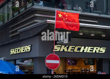 Hongkong, China. 05. Oktober 2022. China-Flagge neben einem amerikanischen Lifestyle- und Performance-Schuhgeschäft der Marke Skechers in Hongkong. (Foto von Sebastian Ng/SOPA Images/Sipa USA) Quelle: SIPA USA/Alamy Live News Stockfoto