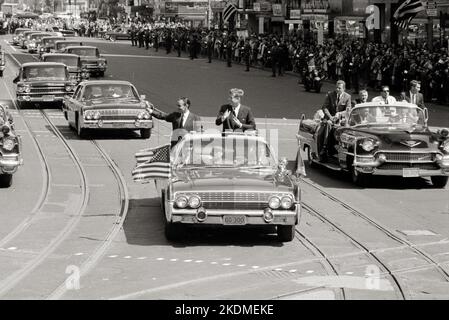 Präsident John F. Kennedy mit König Hassan II. Von Marokko, der während der Begrüßungsparade für Hassan's in einem Auto stand. Stockfoto