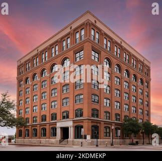 Das Texas School Book Depository in Dallas, Texas, wo Lee Harvey Oswald, der (von den meisten) mutmaßliche Attentäter von Präsident John F. Kennedy, einen Barsch über der Dealey Plaza fand, an dem Kennedy, Texas Gouverneur John Connally, der verwundet wurde. und ihre Frauen fuhren am 22. November 1963 in einem offenen Tourenwagen. Das heutige Sixth Floor Museum wird von der Dallas County Historical Foundation betrieben. Zwischen 1978 und 1981 wurde das Äußere des Gebäudes in seinem ursprünglichen Erscheinungsbild von 1901 und nicht in seinem Erscheinungsbild zum Zeitpunkt des Attentats restauriert. Stockfoto