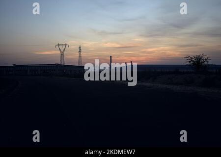 Leere Straße mit verlassenen Lagerhäusern und Pylonen bei Sonnenuntergang Stockfoto