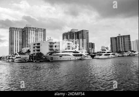 Aventura, Miami, Florida, USA - 6. November 2022: Aventura Landschaft in schwarz-weiß vom Waterway mit Wolkenkratzer, Wasserkanal, Booten und Himmel Stockfoto