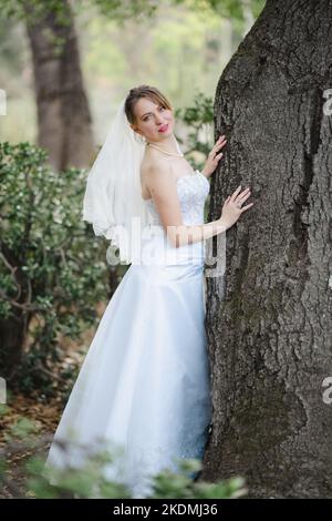 Braut schiebt gegen Eiche in einem Kaktusgarten Stockfoto