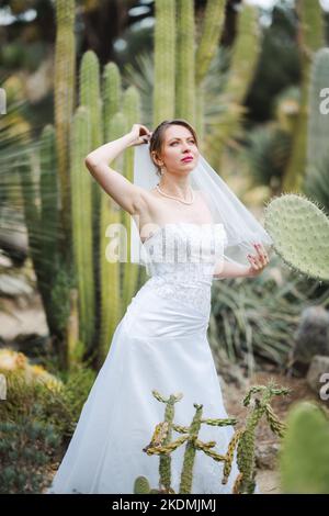 Braut umgeben von Kaktuspflanzen in einem Garten am späten Nachmittag Stockfoto