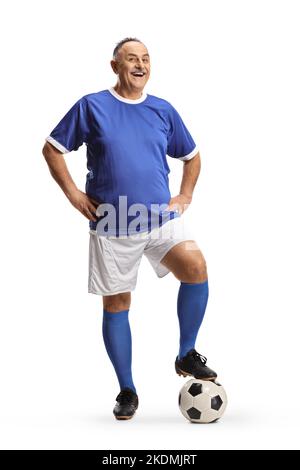 Lächelnder, reifer Mann, der ein Sporttrikot trägt und auf einen Fußball mit weißem Hintergrund tritt Stockfoto