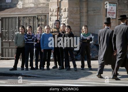 Während der Yeshiva-Pause starren 8 orthodoxe jüdische Jungen, jeder mit langem Peyot, auf etwas auf der anderen Straßenseite. In Brooklyn, New York City. Stockfoto