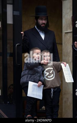 2 orthodoxe jüdische Jungen mit ihrem Rabbinerlehrer warten darauf, dass ihre Eltern sie abholen. Bei einer Yeshiva in Brooklyn, New York. Stockfoto