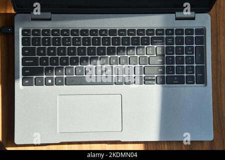 Draufsicht einer grauen Laptop-Tastatur auf einem Holztisch Stockfoto