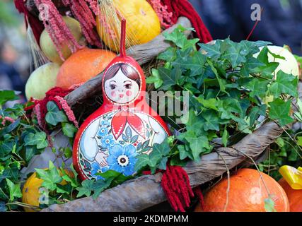 Russische Holzpuppe matryoschka in der Komposition mit Kürbissen. Stockfoto