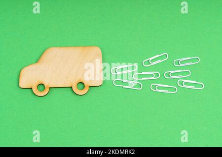 Ökologisches Konzept. Auf einem grünen Hintergrund ist ein LKW aus Holz mit Abgasen als weiße Büroklammern dargestellt. Stockfoto