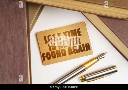 Bildung und Geschäftskonzept. Neben den Büchern liegt ein Stift und ein Schild mit der Aufschrift - Lost Time wird nie wieder gefunden Stockfoto