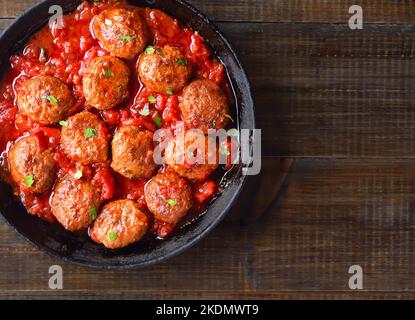 Gebratene Fleischbällchen mit Tomatensauce in einer Pfanne. Draufsicht, flach liegend Stockfoto