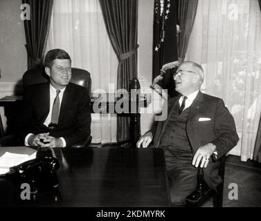 Präsident John F. Kennedy, der sich am ersten vollen Tag Kennedys im Weißen Haus mit dem ehemaligen Präsidenten Harry S. Truman im Oval Office vertrat. 21. Januar 1961 Stockfoto