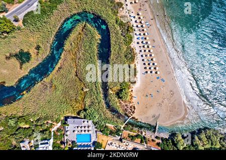 Luftaufnahme (Drohne) des Strandes von Almyros (und des Feuchtgebiets) in der Nähe der Stadt Agios Nikolaos, Präfektur Lasithi, Kreta, Griechenland. Stockfoto