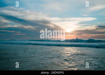 Rosafarbener Sonnenuntergang über dem Meer mit schönem bewölktem Himmel auf dem Hintergrund. Erstaunliche ruhige Szene in sanften hellen Farben, Platz für den Text kopieren Stockfoto