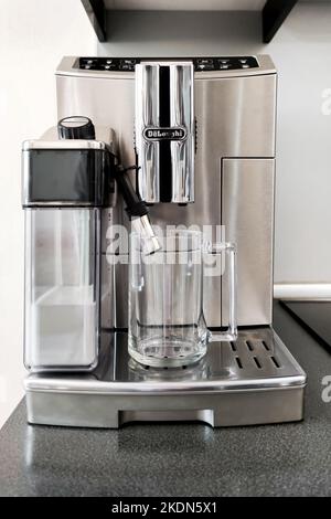 Kaffeemaschine in Stahlfarbe für die Zubereitung verschiedener Kaffeesorten mit Glasbecher auf dem Ständer. Vorbereitung für die Zubereitung von Kaffee Stockfoto