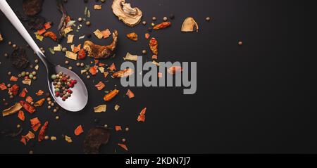 Nahaufnahme von getrockenen Gewürzen wie Chilipilzen und Pfeffer auf dunkler Oberfläche oder Tisch mit Variationen in der feinen Küche mit Kopierfläche Stockfoto